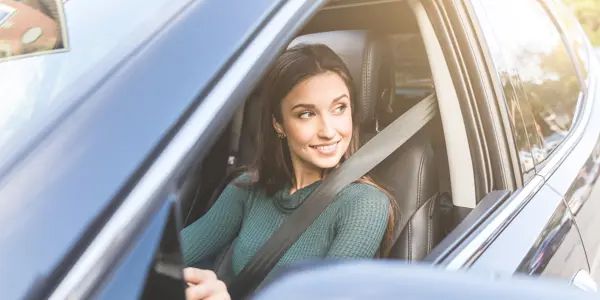 Femme souriante dans une voiture
